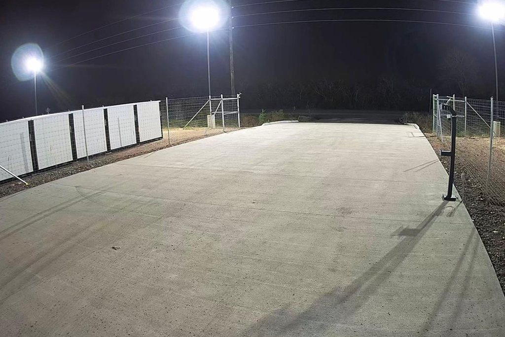 A well-lit truck parking facility at night in Houston.